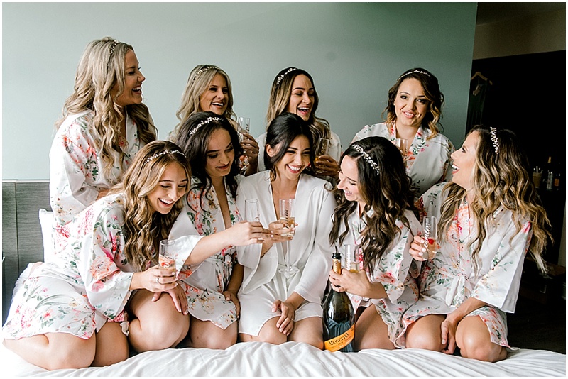 bridesmaids laughing on bed